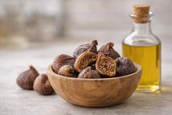 Smochine uscate într-un bol rustic, alături de ulei de măsline, pe fundal de bucătărie