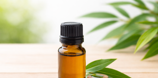 De ce este bine să ai în casă ulei de arbore de ceai. Un produs simplu, cu utilizări surprinzătoare Flacon cu ulei esențial din arbore de ceai pe fundal natural