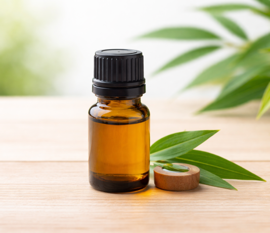 De ce este bine să ai în casă ulei de arbore de ceai. Un produs simplu, cu utilizări surprinzătoare Flacon cu ulei esențial din arbore de ceai pe fundal natural
