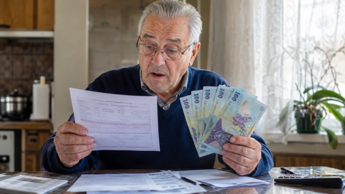 Pensionar analizând talonul de pensie și calculele unei posibile majorări din 2027