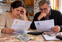 Familie din România verificând facturile la energia electrică și gazele naturale, în contextul noilor ajutoare propuse pentru venituri de până la 3.500 de lei.